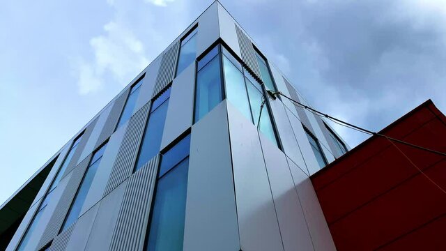 Static footage of the exterior of building being mopped and cleaned with a long mop handle. View from below.