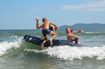 Caucasian children outdoor in summer swimming with inflatable mattress