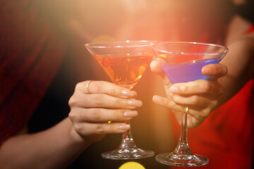 Halloween party. two young woman in witch halloween costumes for Halloween party posing with glasses of cocktails