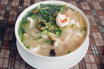 Thai spicy tom yam seafood served on white bowl in local restaurant.