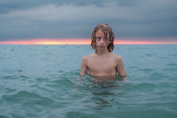 Young teenage boy enjoys the sea at the beach. © Luka