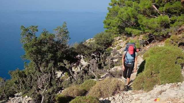 Young woman with backpack walk the Lycian way hiking trail in Turkey.