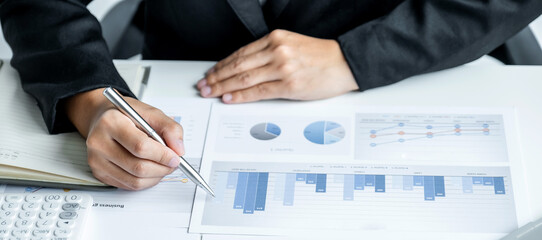 Businesswoman analysis the chart with laptop at the office for setting challenging business goals...