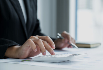 businesswomen bookkeeper use calculator and laptop doing account for paying tax on white desk in working office
