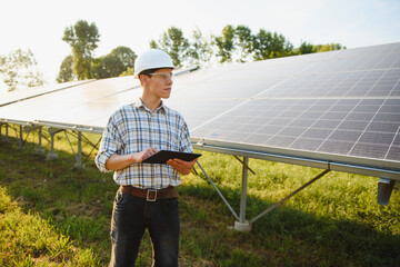 Engineers checking solar panels. Renewable energy.