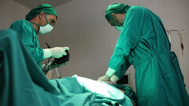 Doctors are helping patients with machines defibrillation.