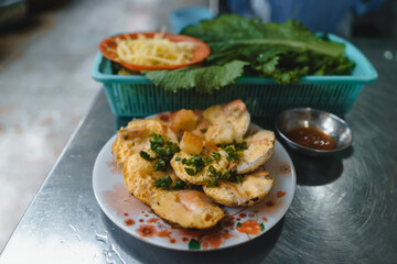 Vietnamese street food "banh can" make by rice powder with rice flour, egg, onion leaves. Banh can is a portion of Vietnamese street food.