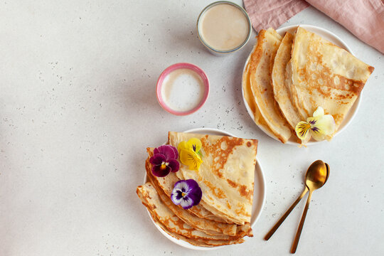 Delicious crepes on plates, coffee mugs. Concept of Breakfast, dessert, recipe, French cuisine, Maslenitsa.