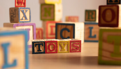 Word "Toys" written with wooden blocks - Powered by Adobe