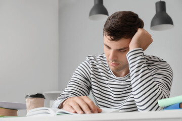 Obraz premium Young man studying with books and coffee, academic pressure, stress, and concentration for education and learning