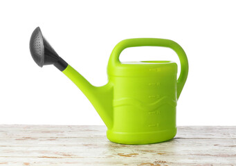 Watering can on table against white background