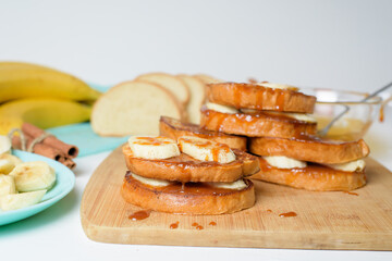 French toast with banana and homemade caramel with cinnamon, Breakfast dessert on a blue plate on a light background