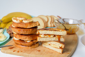 French toast with banana and homemade caramel with cinnamon, Breakfast dessert on a blue plate on a light background