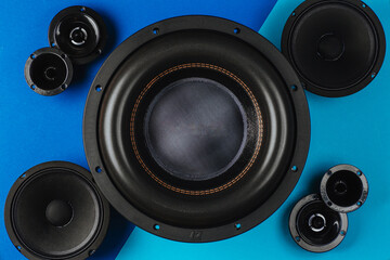 Car audio, car speakers, black subwoofer on a blue- light blue background. Close up