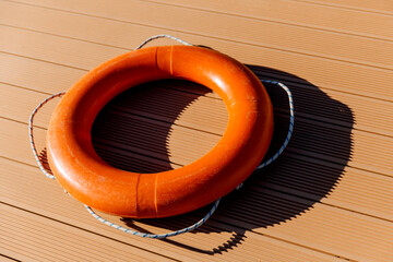 An orange lifebuoy lies on a cracked background. Water safety concept