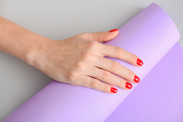 Hand with beautiful manicure on light background