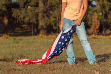 Woman with a flag of United States of America in the hands, outdoors