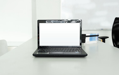 Fototapeta premium Laptop with blank screen for your product, information display on white desk meeting room interior or office background.