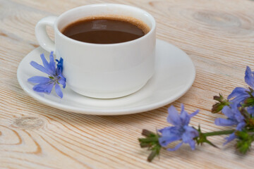 Obraz na płótnie Canvas hot chicory drink with blue flowers on wooden table