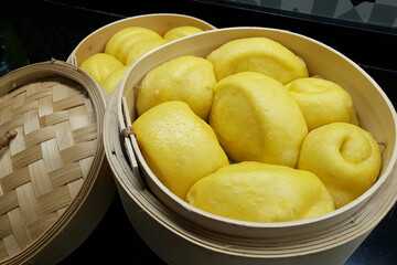 Homemade steamed pumpkin buns in bamboo steamer.