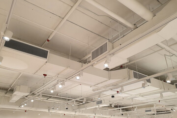 Ventilation pipes in silver insulation material hanging from the ceiling inside the new building.