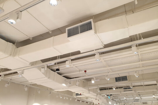Ventilation pipes in silver insulation material hanging from the ceiling inside the new building.