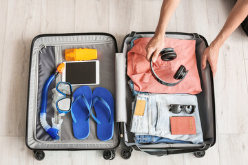 Man packing suitcase at home. Travel concept