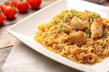 Plate with tasty pilaf on table, closeup
