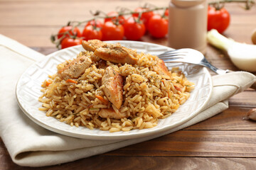 Plate with tasty pilaf on table