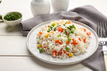 Plate with tasty pilaf on table