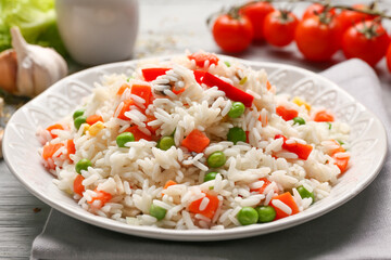 Plate with tasty pilaf on table
