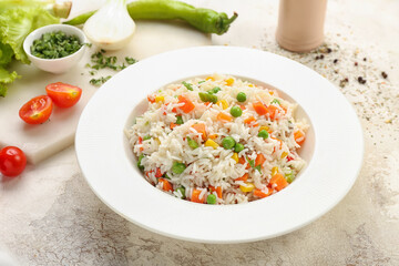 Plate with tasty pilaf on light background
