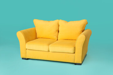 Stylish sofa on color background