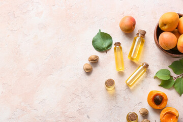 Bottles of apricot essential oil on light background