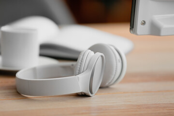 Modern headphones on table in office