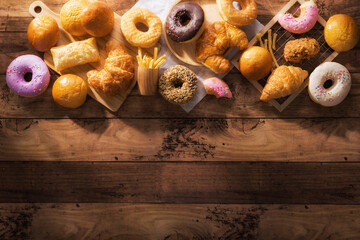 assorted junk food multiple type on wooden table of top view with copy space