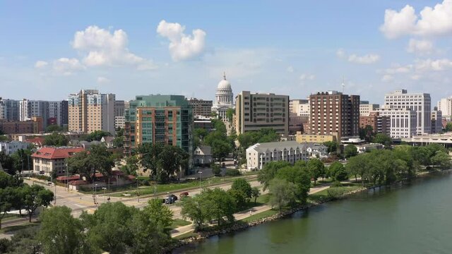 Aerial above Lake Monona and main street in Madison, city skyline at background