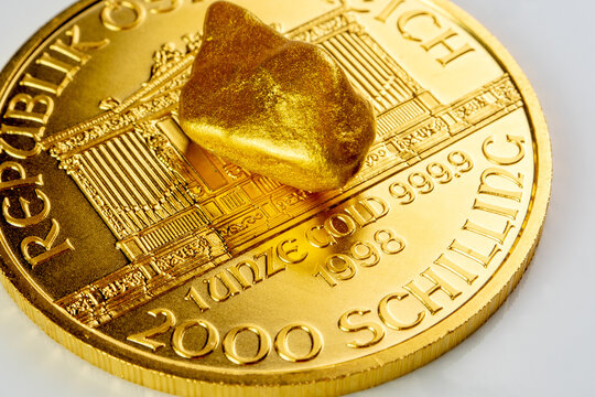 golden austrian philharmoniker one ounce coin laying on a heap of golden nuggets, golden ore