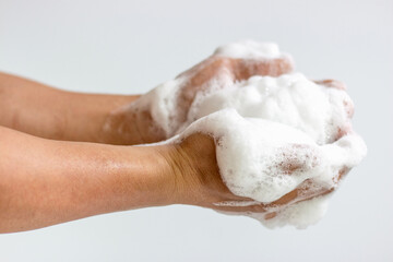 A large amount of foam on men's hands on white background, front view