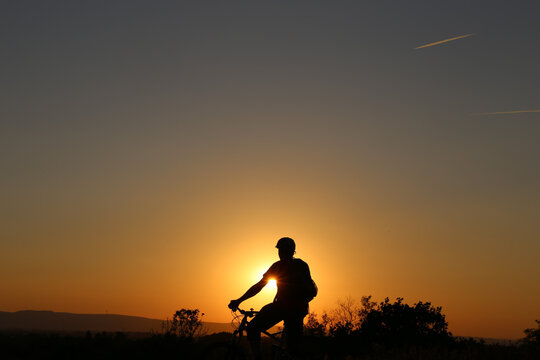 Symbolbild: Silhouette eines Mountainbikers an einem warmen Sommerabend