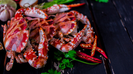 Cooked steamed blue swimming crab or caught flower crab on on black wooden table.