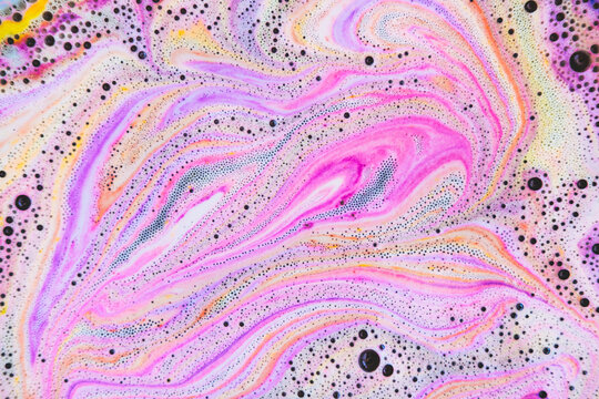 Colorful rainbow bath foam with bubbles in the water. Galaxy imagination. Marble texture effect. Beauty and luxury background. Flat lay, top view, abstract art.