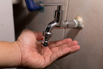 Cropped Hand Of Plumber Repairing Faucet At Home