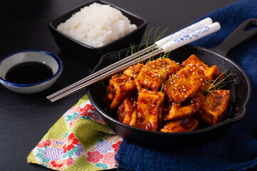 Healthy Asian food concept Homemade stirs fried spicy chili sauce, organic tofu in skillet iron pan with copy space