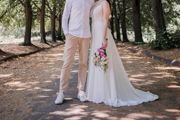 groom with bride in wedding dress in summer park