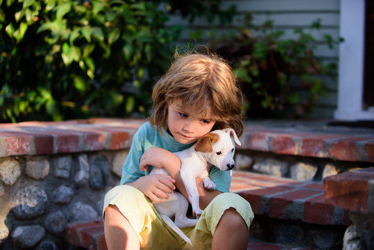 Child lovingly embraces his pet dog. Portrait of a little cute boy kid with doggy relaxing on nature.