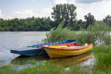 Old wooden fishing boats on a pond. Traditional small fishing boats on river bank in northern part of Serbia.