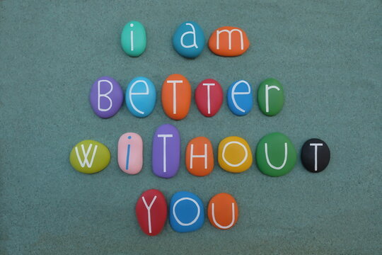 Naklejki I am better without you, negative slogan composed with multicolored stone letters over green sand