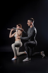 Fototapeta na wymiar a man and a woman are engaged in sports in the hands of dumbbells