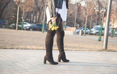 Obraz premium Caucasian young girl holding yellow flowers in outdoors.